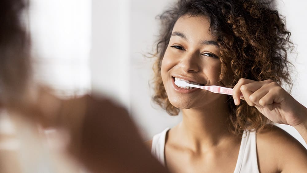 Børst tennene minst to ganger om dagen eller som anvist av en tannlege eller tannpleier.