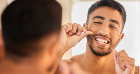 Mann som bruker tanntråd