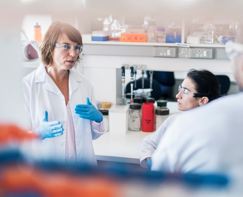 Bilde av to forskere i et laboratorium, med hvite frakker og vernebriller